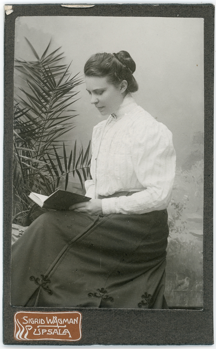 Kabinettsfotografi - kvinna sitter med en bok i knät