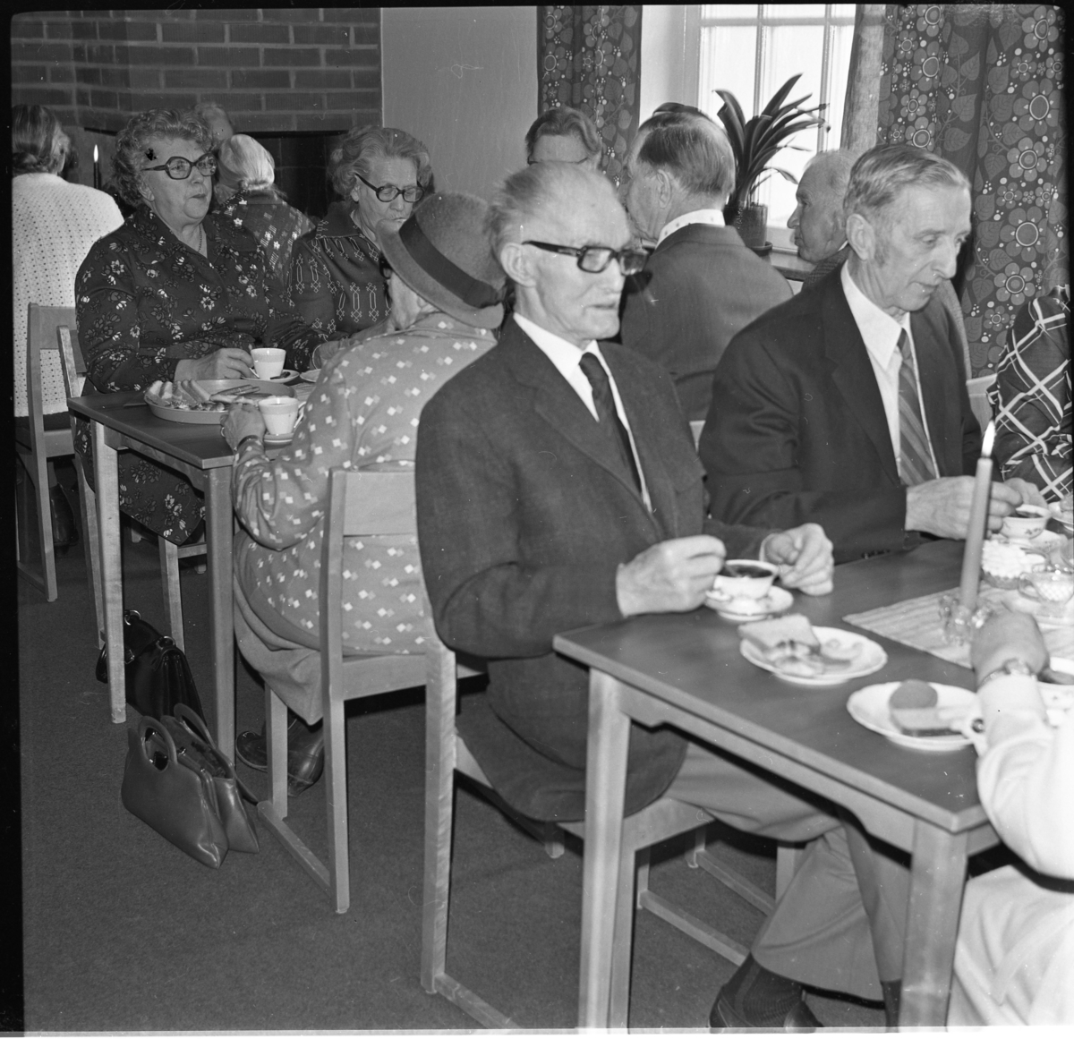 Äldre kvinnor och män sitter vid kaffebord med tända ljus. Det är Filadelfia-församlingen i Gränna som arrangerar "De äldres fest". Längst fram till höger sitter Carl Pragberg.