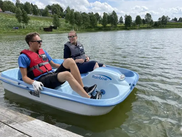 To mennesker sitter i en pedalbåt og smiler til hverandre. De er ute på Doktortjønna på Røros.. Foto/Photo