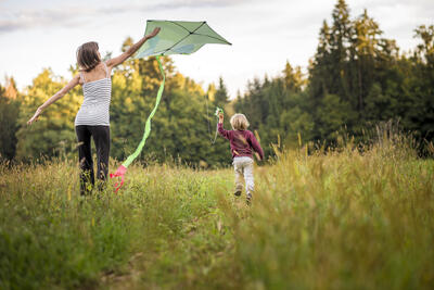 young-mother-helping-her-child-to-fly-a-kite-2021-08-26-22-28-01-utc.jpg. Foto/Photo
