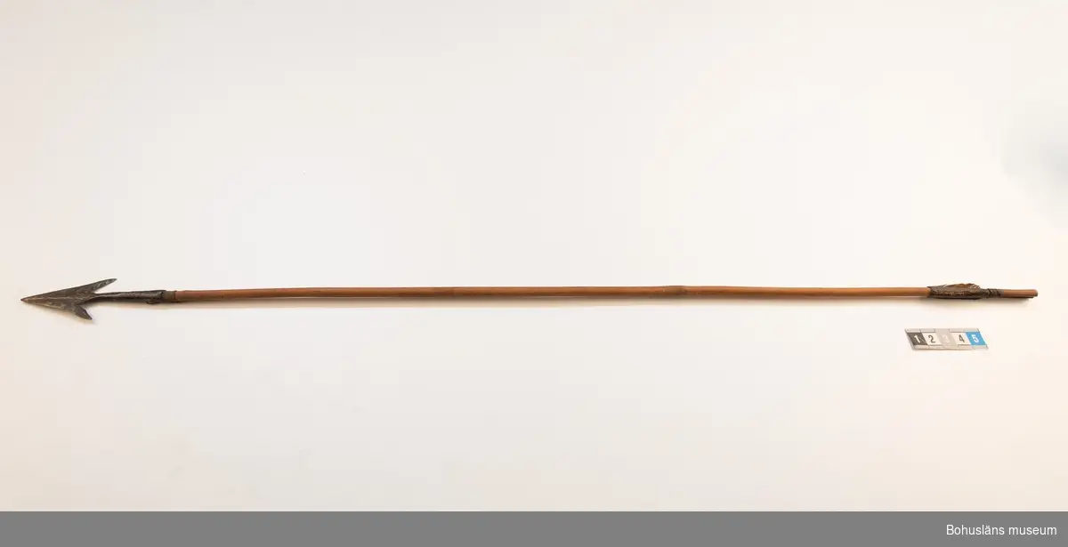 Ur handskrivna katalogen 1957-1958:
Båge m. 17 pilar, Afrika
Bågen a) L.103 cm; m. sträng av en vidja; i bågens ändar runda träkulor. Hel.
b-l, 3- kantiga m. smal svart fastsurrad träspets m. hullingar.
b-c, L. 72 och 71,2 cm; har blad infällda i ändan som styrfjädrar.
d-k, L. 75,5; 72; 71,8; 71,8; 71,6; 71,5; 76,6; 66 cm; lika b och c men saknar styrfjädrar;
k upptrasad i ändan.
l, L. 55,5; av ngt annan typ än föreg, har haft spets och styrfjädrar, vila saknas.
m-r, runda skaft, styrfjädrar, spetsen av järn m. hullingar (ej 791 m) och holk f. fastsättn.
L. 69; 68,1; 76,4; 65; 64,7; 61,3 cm;
("r" saknar spets; n och q saknar en hulling. "o" saknar 2 styrfjädrar; "p" saknar ena delen i "klykan" f. strängen)
R: vid inventering 2022 har R pilspets medan O saknar pilspets.

Ur Knut Adrian Anderssons Katalog II 1916:
No 22, nr 7, 8 ,9 på etiketten i Elmer Göranssons samling. Båge av trä m. sena till sträng jämte 17 förgiftade pilar av två typer med hullingar. Från Mogala i Belgiska Congo.

Artikel i Bohusläningen måndagen den 1 november 1937, "Vittberesta bohusläningar berätta. Upplevelser under 30-årig vistelse i Belgiska Kongo. Kapen Elmer Göransson. Folk och sedvänjor under ekvatorns glödande sol."

UMFA54467:0588 visar porträtt på sjökapten Elmer Göransson i uniform med ett antal ordnar och utmärkelser. Fotograf Thure Nihlén, Uddevalla.