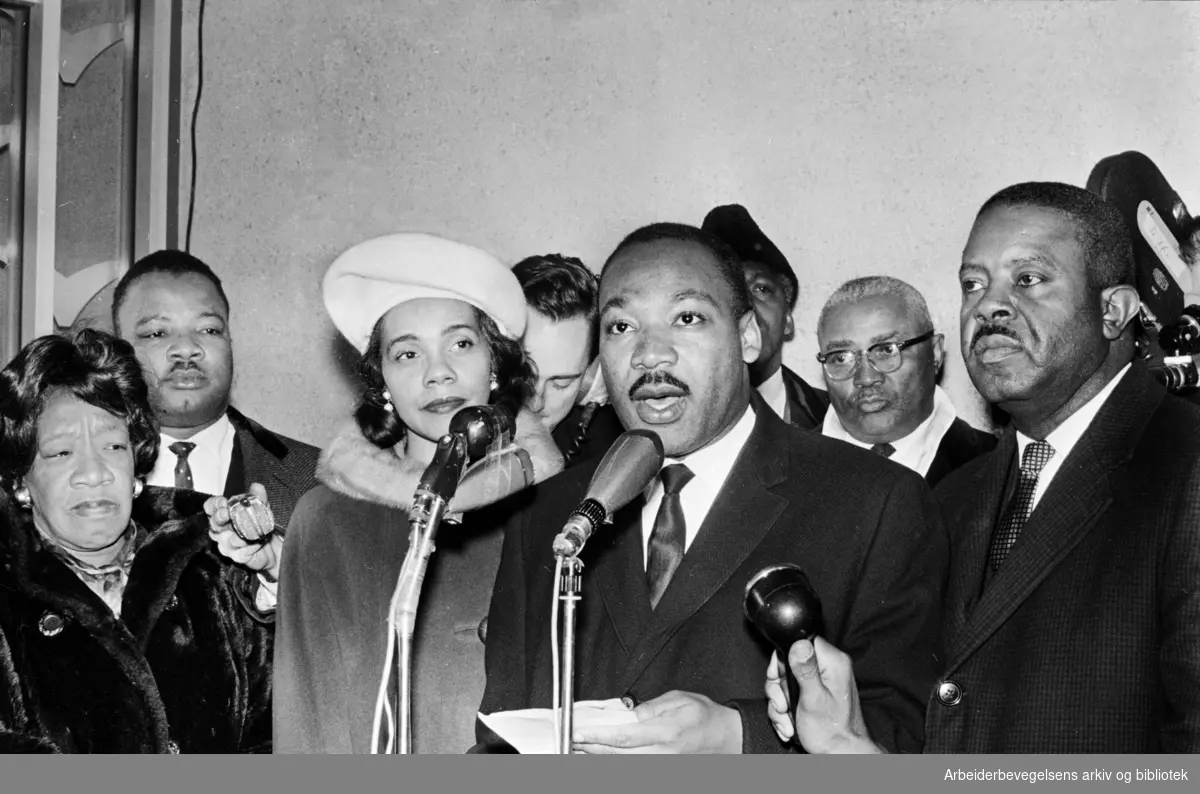 Pressekonferanse. Dr. Martin Luther King jr. ankommer Oslo lufthavn Fornebu i anledning utdelingen av Nobels Fredspris. Hans kone, Coretta Scott King t.v. Desember 1964.
