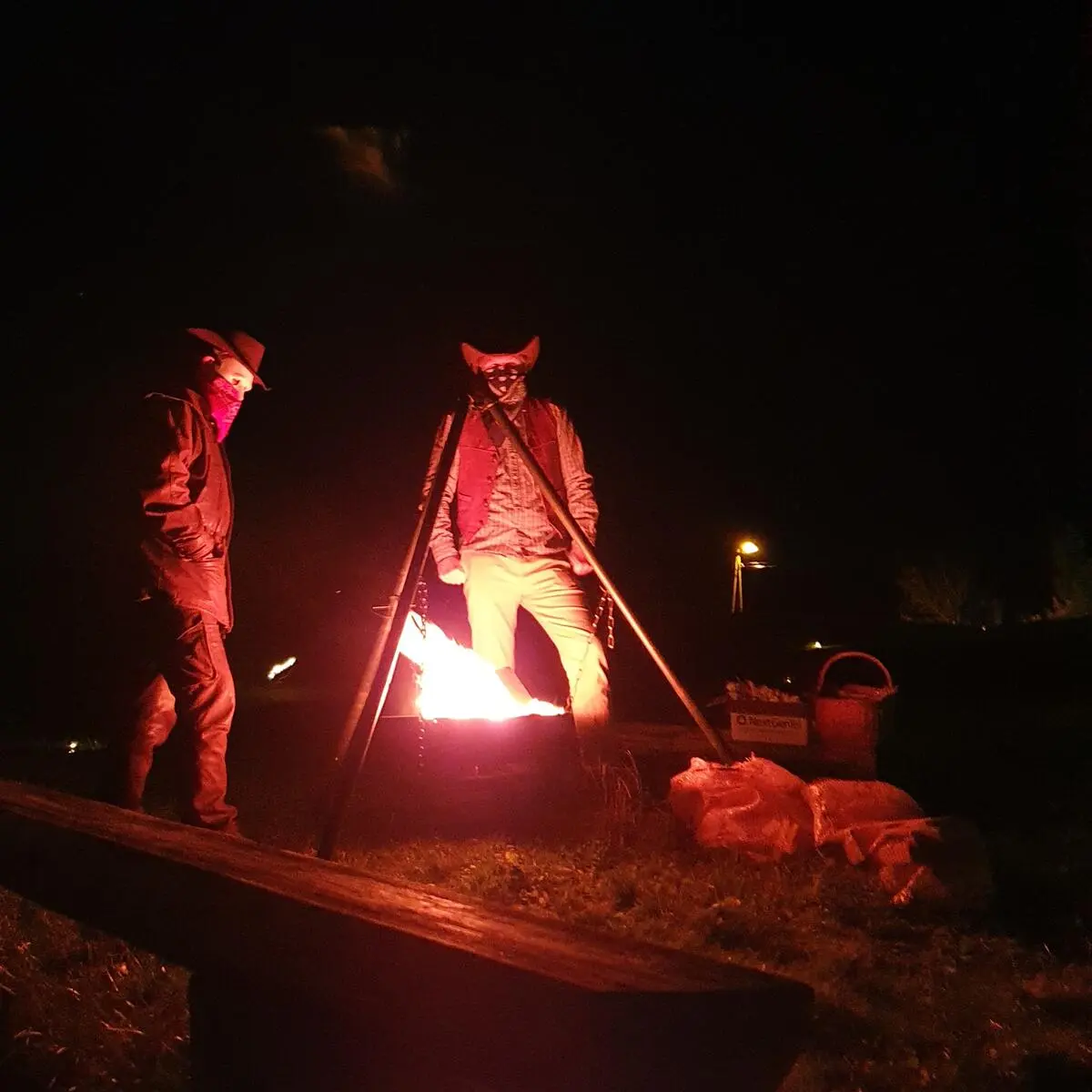 Cowboyer ved bålpannen i kveldsmørket