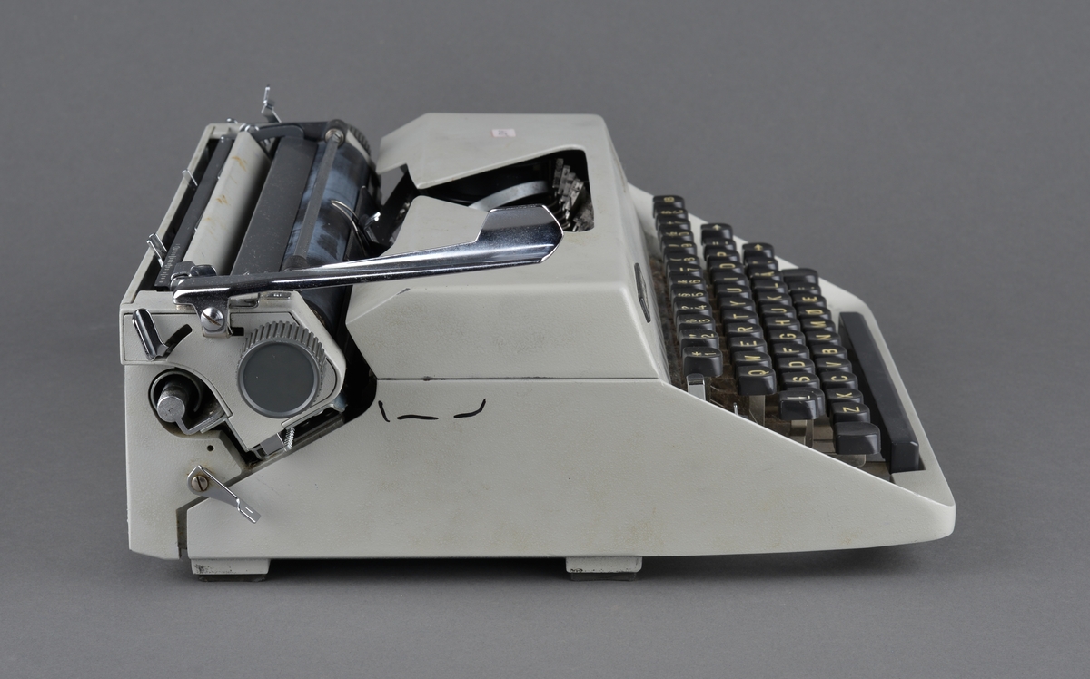 Mekanisk skrivemaskin. Plassert i koffert, men sansynligvis ikke beregnet på reisevirksomhet.