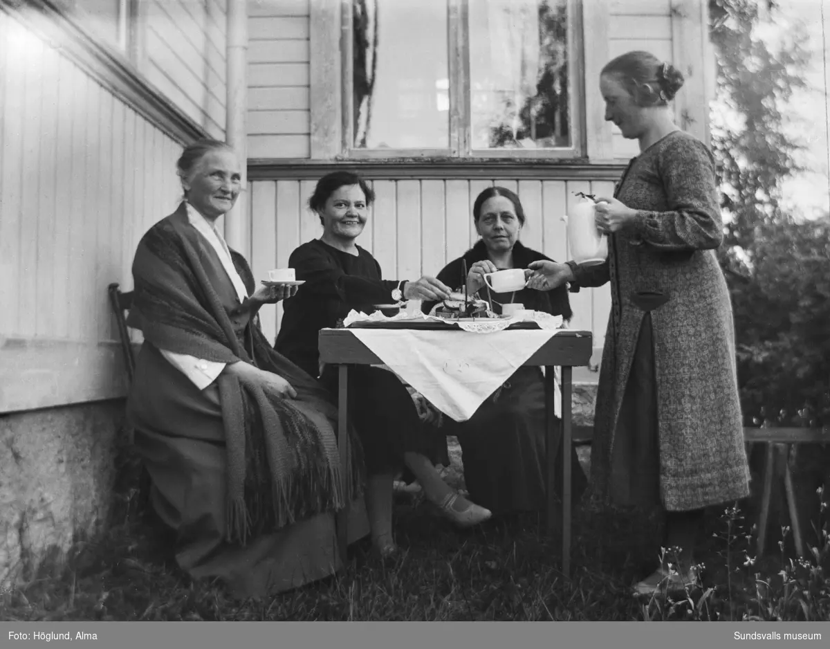 Göta Bäckström, Fanbyn, serverar tre damer kaffe utomhus. Längst till vänster hennes mor Eva Bäckström.