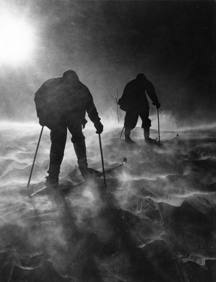 Foto av to skiløpere i snøstorm.