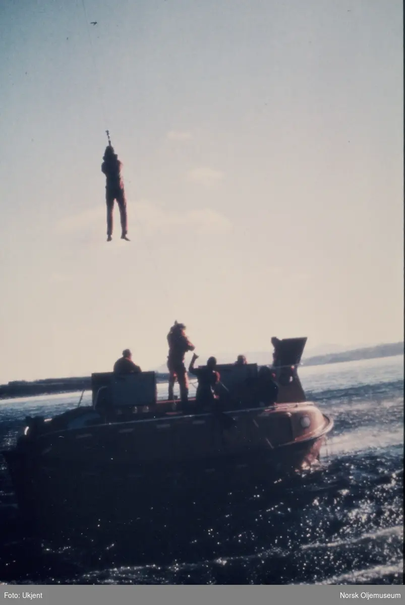 En mann blir heist opp til et helikopter fra en livbåt under en redningsøvelse.