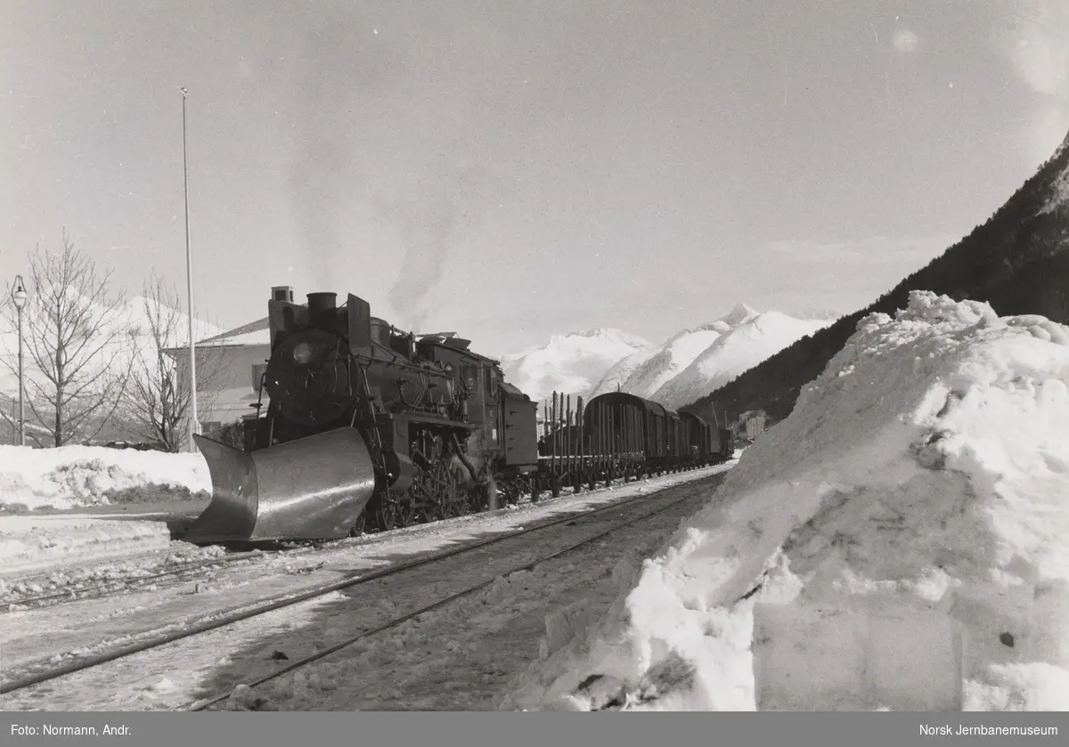 Damplokomotiv type 26c med stor frontplog med godstog retning Dombås på Åndalsnes stasjon