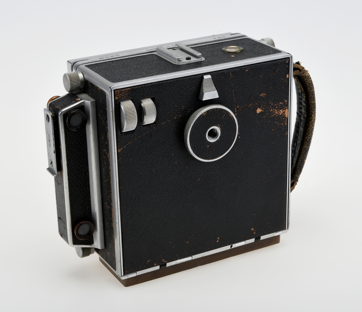 Et storformat belgkamera for plater på 9x12cm fra Linhof, med et 150mm fastobjektiv. Linhof er i dag den eldste kameraprodusenten i verden som fortsatt produserer kameraer etter at Gandolfi og Kodak sluttet deres produksjon.    

Foran på kameraet er det en luke som kan åpnes opp for å dra fram belgen som er festet på en skinne på innsiden av luken. Belgen kan flyttes fram og tilbake på skinnen, og objektivplaten kan også flyttes sideveis, i høyden eller tippes bakover. Objektivet og lukkerhuset er montert på en avtagbar plate i front av belgen. På lukkerhuset er det et hjul for å stille inn lukkertiden og en liten spake for å justere blenderåpningen. 

På baksiden av kameraet er det en luke til filmplater med en mattskive inni. På luken er det en svart solskjerm som kan brettes ut. På den en siden av kamerahuset er det en søker med en rammesøkermekanisme koblet til fokusmekanismen foran på belgskinnen. Søkeren har en holder til en blitslampe. På toppen av kamerahuset er det en tilbehørssko og et vater. Kameraet er dekket i svart skinn. Håndtak i skinn på siden. kameraet har stativfester både under kamerahuset og under luken til belgen.