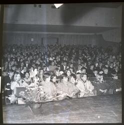 Fotografi av et publikum av jenter og gutter og menn og kvin