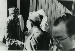 Fotografi av Folke Bernadotte som tar en soldat kledd i en u
