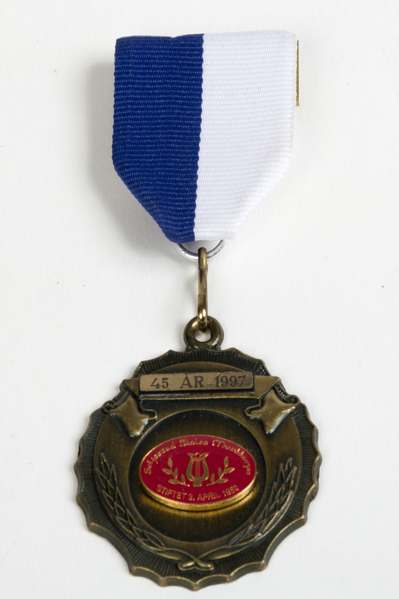 Medalje for Seljestand Skoles Musikkorps med kort bånd i blått og hvitt med nål