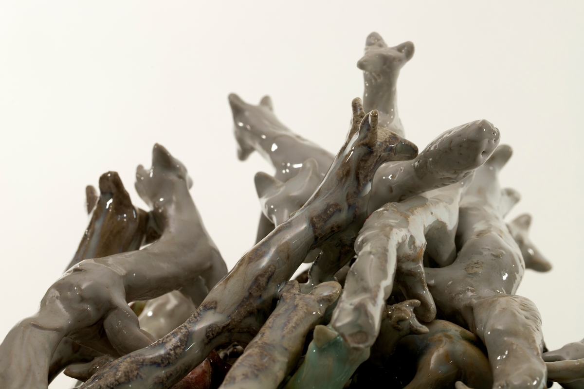 Skulptur med konisk form. Satt sammen av "stablede" revefigurer i porselen over en steingodsbase.