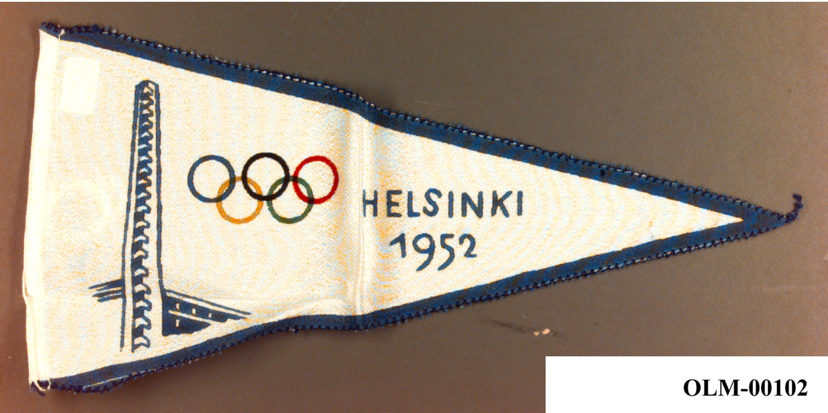 Hvit og blå vimpel med logo for de olympiske sommerleker i Helsingfors i 1952. I logoen inngår det motiv av tårnet på Helsinkis olympiske stadion og de olympiske ringene.