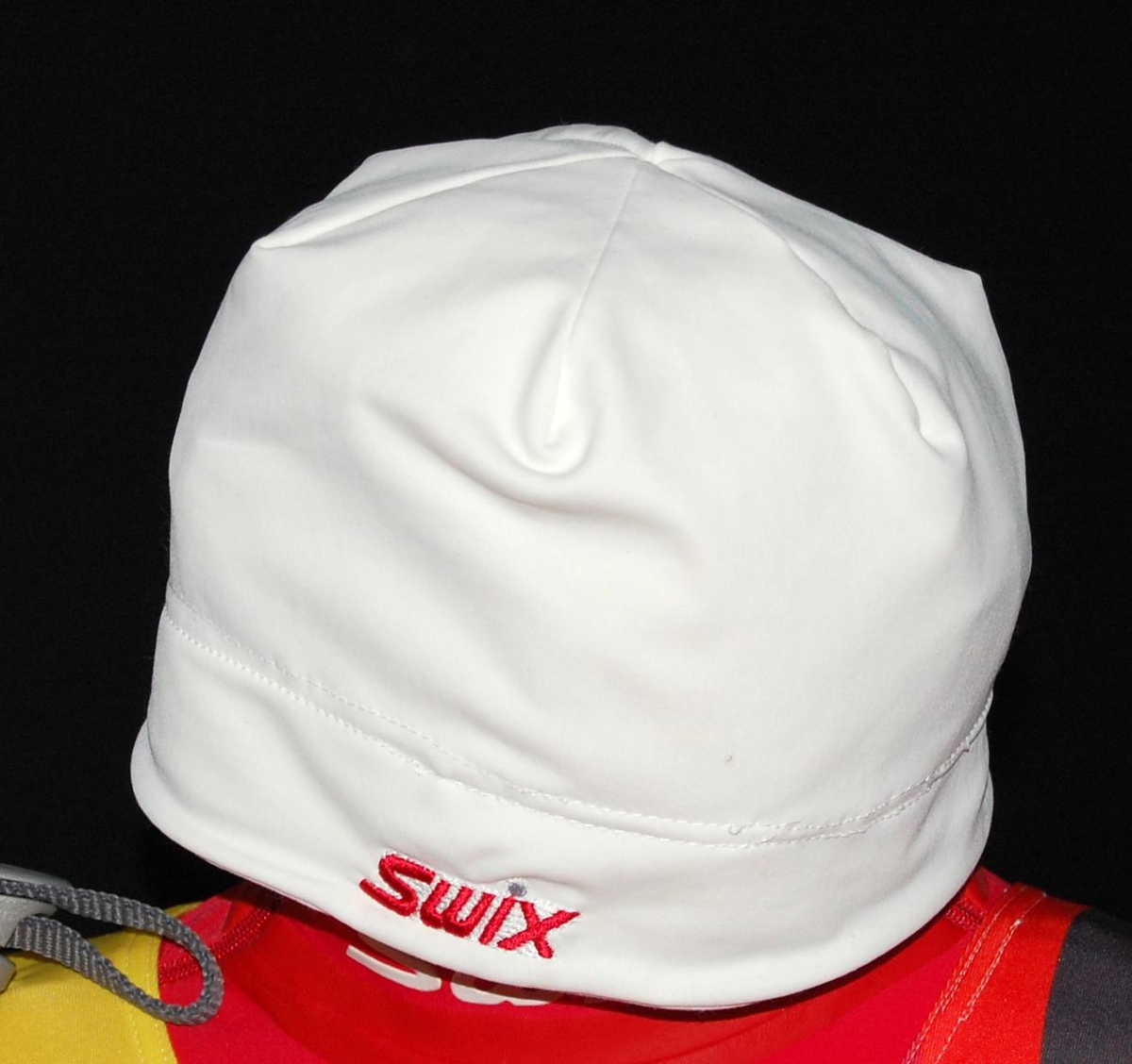 Hvit lue med rød Swix-logo.