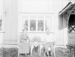 Kvinne og mann forran hus på Grimsrud. Grimsrud og frue.