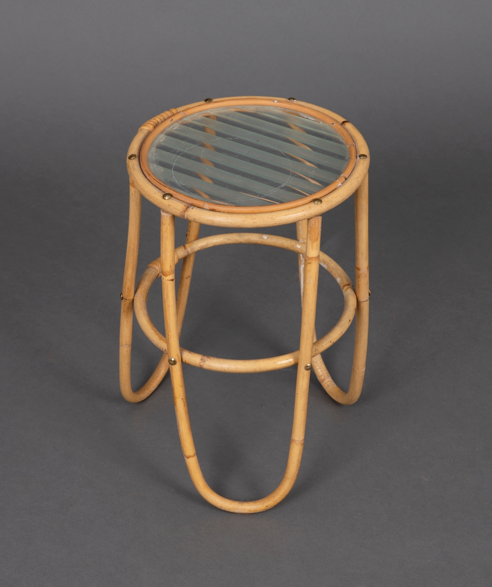 Lite bord med tre føtter i flettet rattan og glasstopp. Glasset er delvis frostet med et stripete mønster.