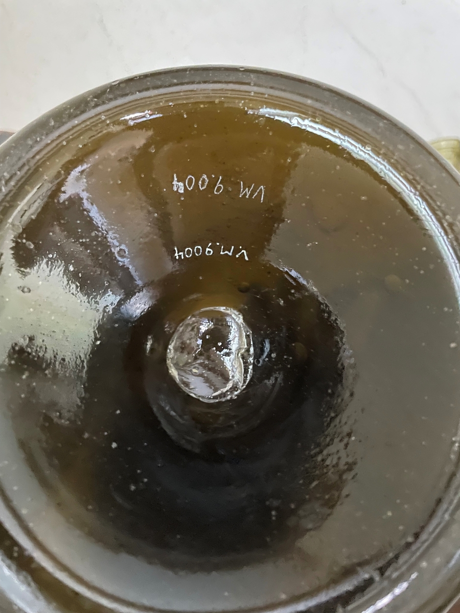 Flaska av grönbrunt glas, långhalsad med botten uppskjuten.