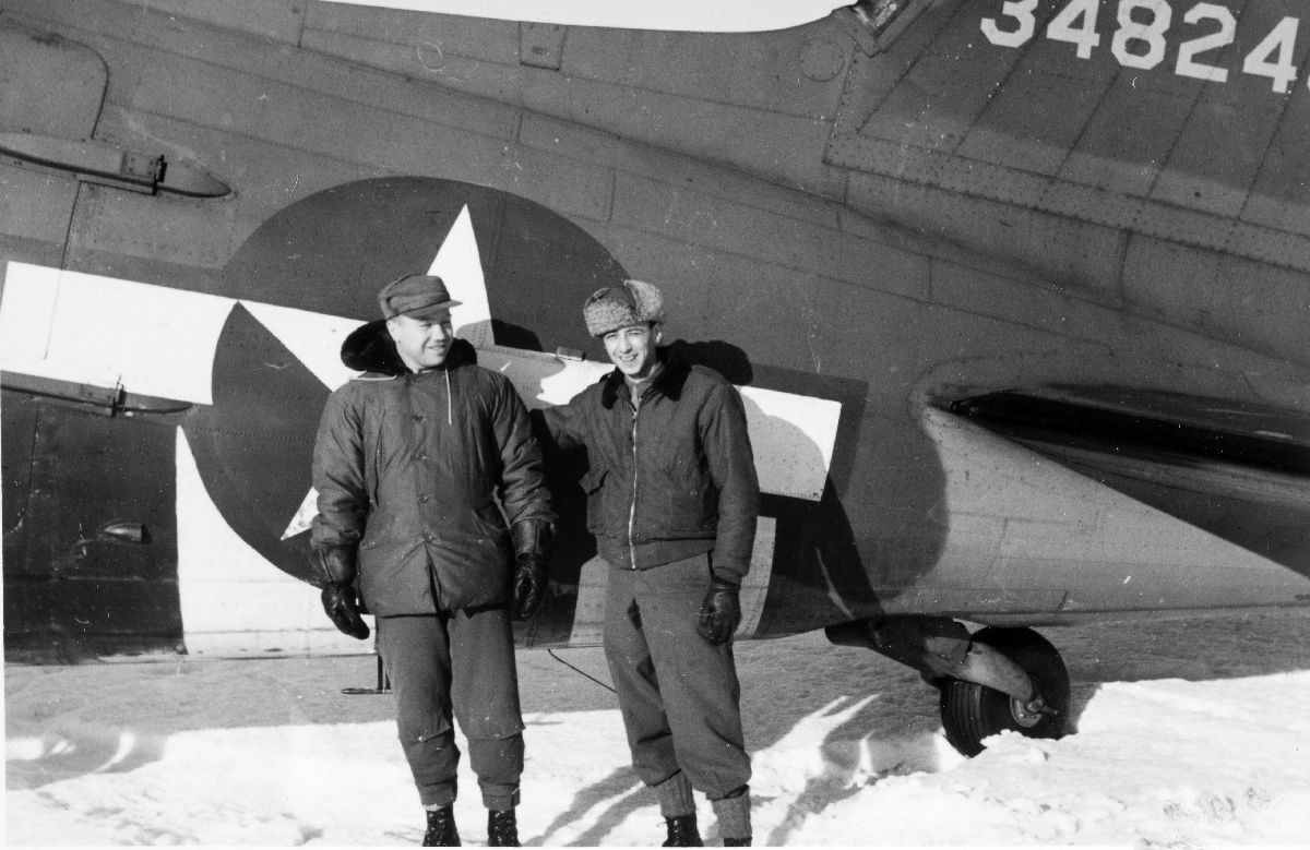 To medlemmer av den amerikanske transportavdeling oppstilt foran sitt DC-47 transportfly. Til høyre står Alexander Dubrowen, avdelingens tolk.