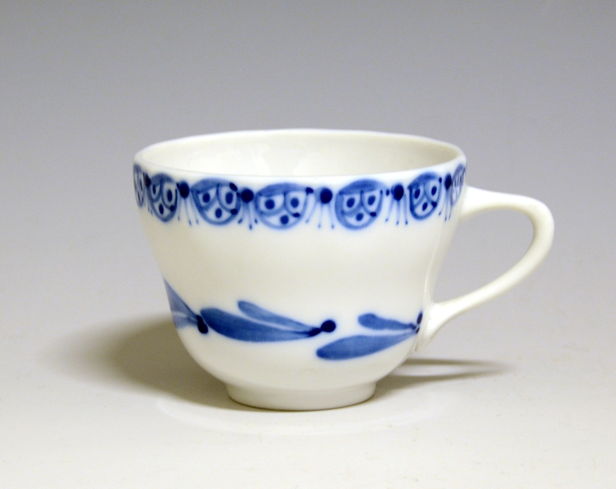 Kaffekopp av porselen. Håndmalt blomsterdekor med blå blomster i underglasur.
Modell: 1800, Victoria
Prøve. Uten fabrikkmerke.
