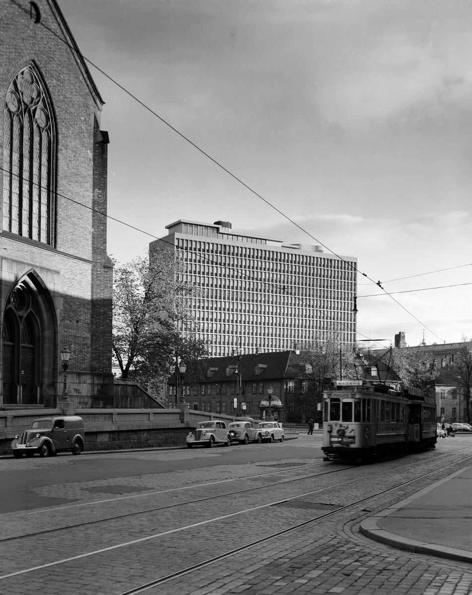 Regjeringsbygningen sett fra Akersgata ved Trefoldighetskirken. Trikk kjører forbi. Slutten av 1950-tallet.