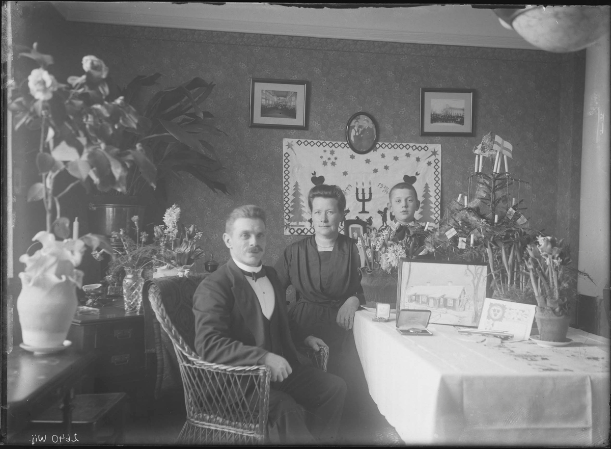 Fotografering beställd av Fahlin. Föreställer sannolikt Karl Axel Fahlin (1874-1968) med hans hustru Agda Lovisa Borg (1881-1962) och deras fosterson barnhusbarnet Karl Axel Fredriksson (1915-1998).