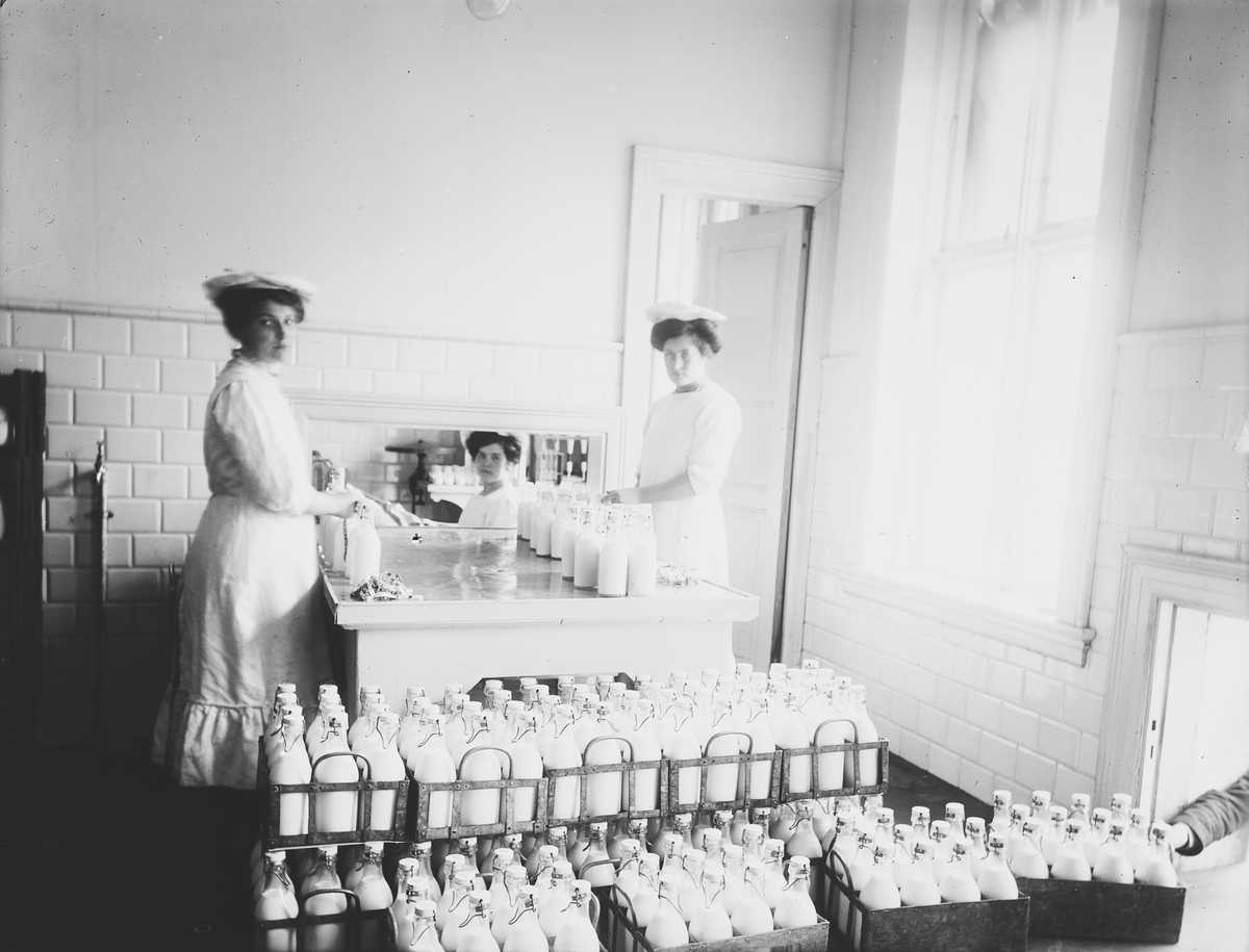 To kvinner fyller melkeflasker for De Forenede Meierier. Fotografert 1911.