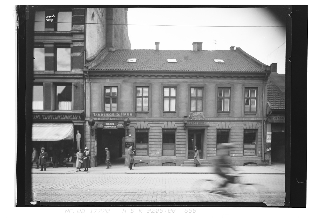 Butikker, kontorer, apotek og fotgjengere i Storgata. Fotografert 1924.