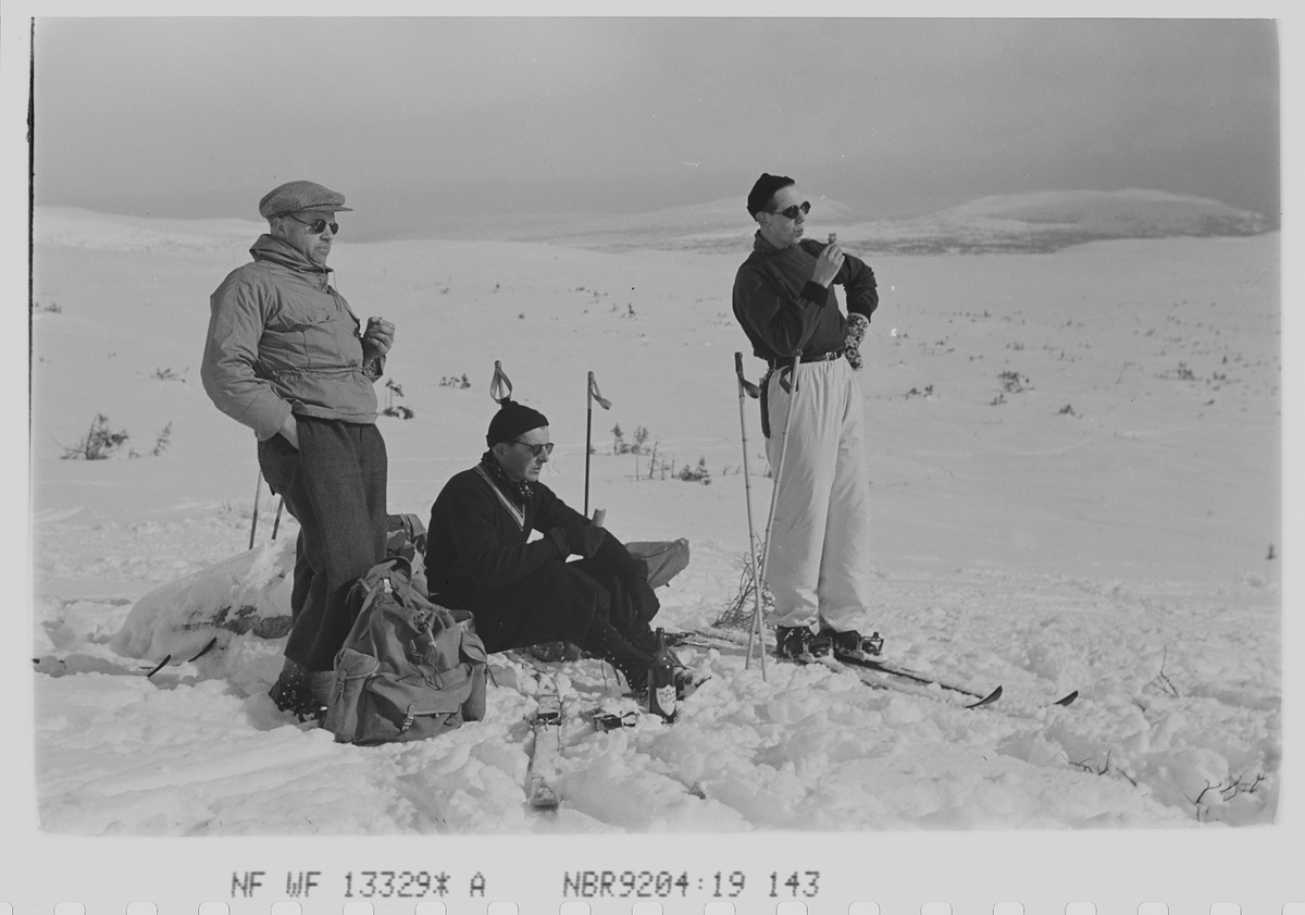 Tre menn på ski tar pust på påsketuren. Fotografert 1940.