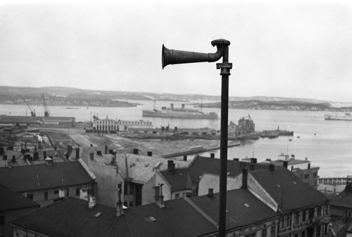 Varselsirene antatt avbildet fra Ruseløkka, utsikt over Oslo Havn og Oslofjorden, Havnelageret i bakgrunnen. Fotografert 1940.