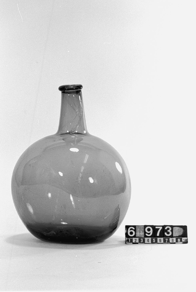 Flaska av grönt glas. Diameter: 160 och 210 mm.