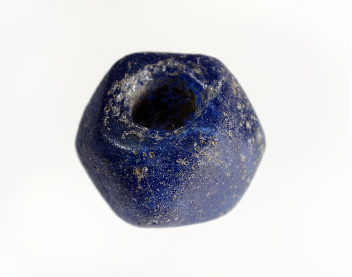 Mørk blå fasettert glassperle, fremkom under vasking av jordprøve