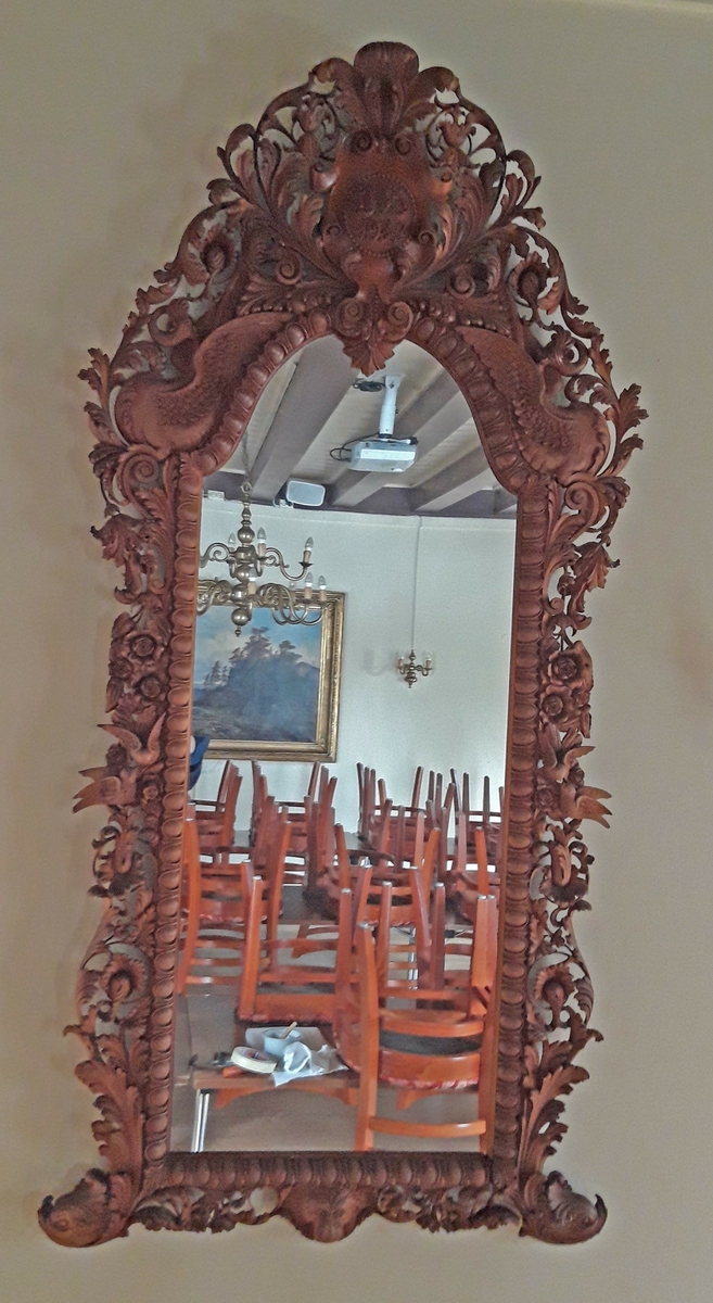 Speilramme av mahogny skåret av John Haslebræk. Gårdbruker fra 1898 i Stange etter mange år i USA.