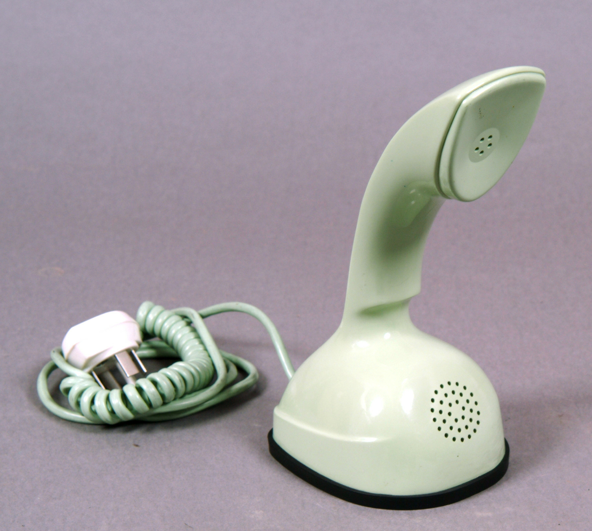 Telefonapparat Ericofon, även kallad Kobra, för AT-system, huvudapparat (med ringklocka), anknytningsapparat till växel (med ringklocka) och sidoapparat (utan ringklocka). Bordsmodell, m57, av grön termoplast utan inbyggd ringklocka och med alla komponenter sammansatta till en enhet. När telefonen används som huvud- eller anknytningsapparat ansluts en separat väggmonterad avstängningsbar ringklocka. Fingerskivan av plast är försänkt i apparatfoten. Klykfunktionen är realiserad med en knapp som skjuter ut ur fingerskivans centrum och påverkas av apparatens tyngd. Med spiralsladd och propp.