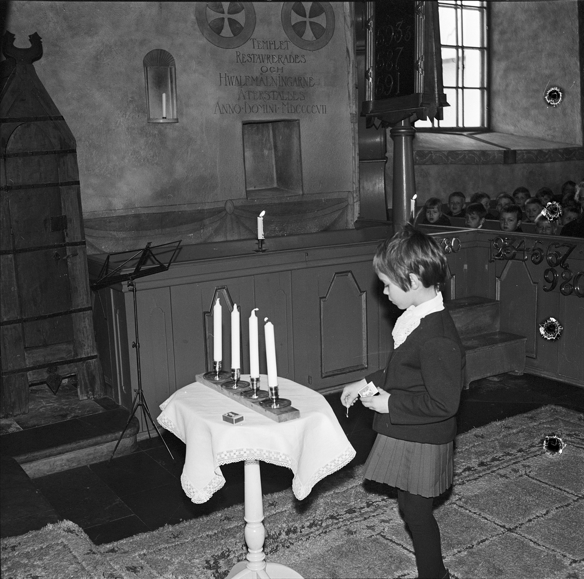 Flicka tänder första ljuset vid advent i Villberga kyrka, Uppland 1965