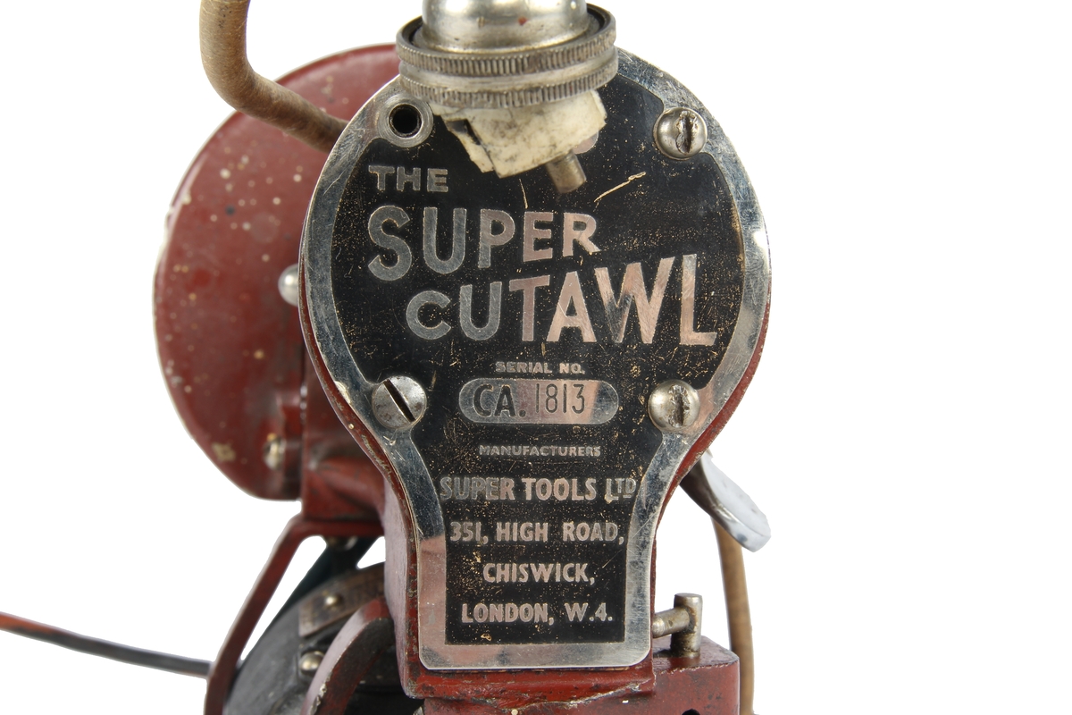 Elektrisk stikksag av typen «The Super Cutawl», produsert av «Super Tools ltd.» Chiswick, London. Den er lakkert i en rødbrun farge, mens selve elektromotoren er lakkert i en sort «krympelakk»
