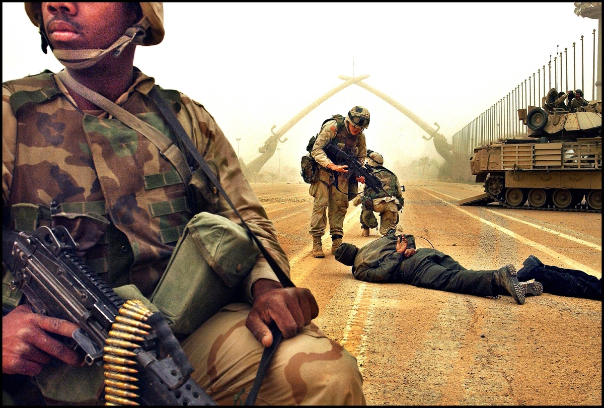 Amerikanske soldater og en fange, Paradeplassen, Bagdad sentrum. Sverdene i bakgrunnen er seiersmonument etter Iran/Irak-krigen 2003.