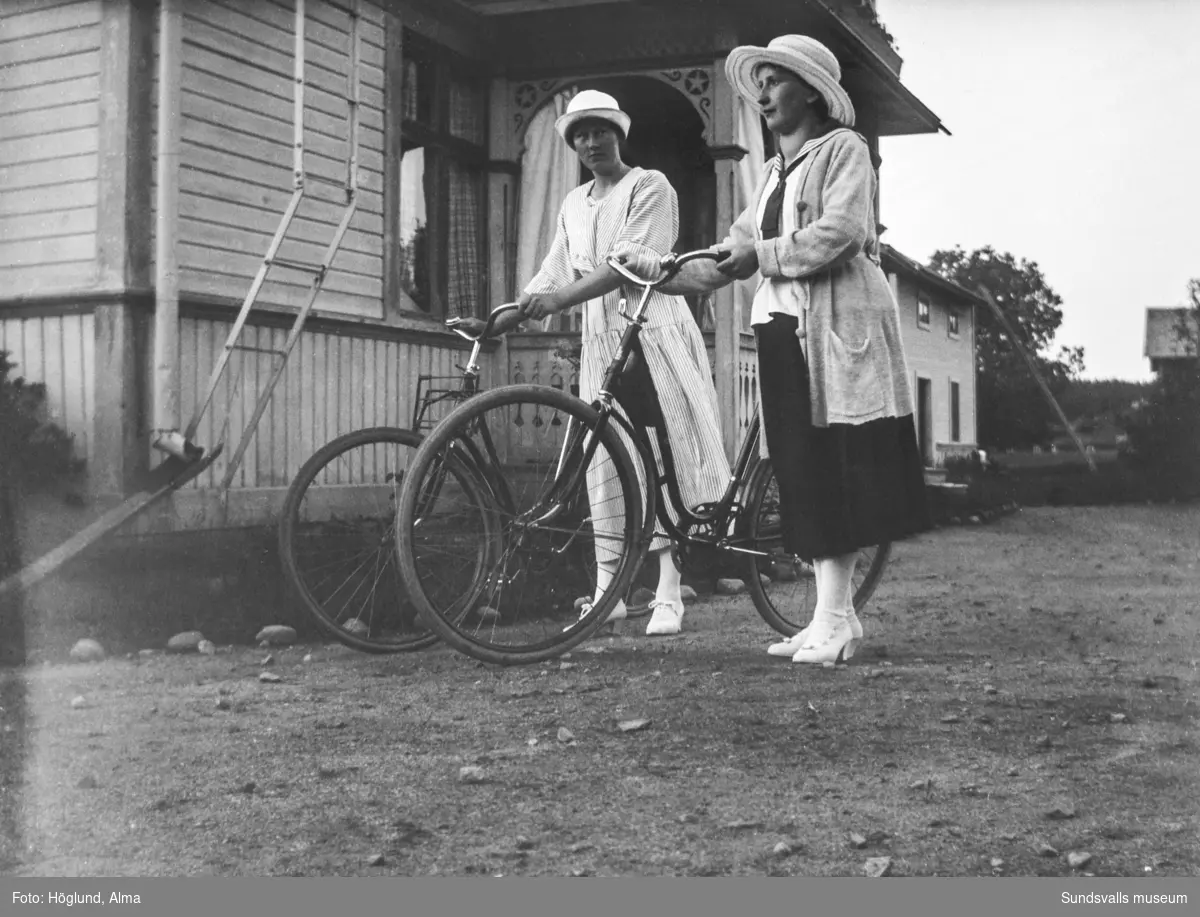 Två unga kvinnor med cyklar, till höger Göta Bäckström.