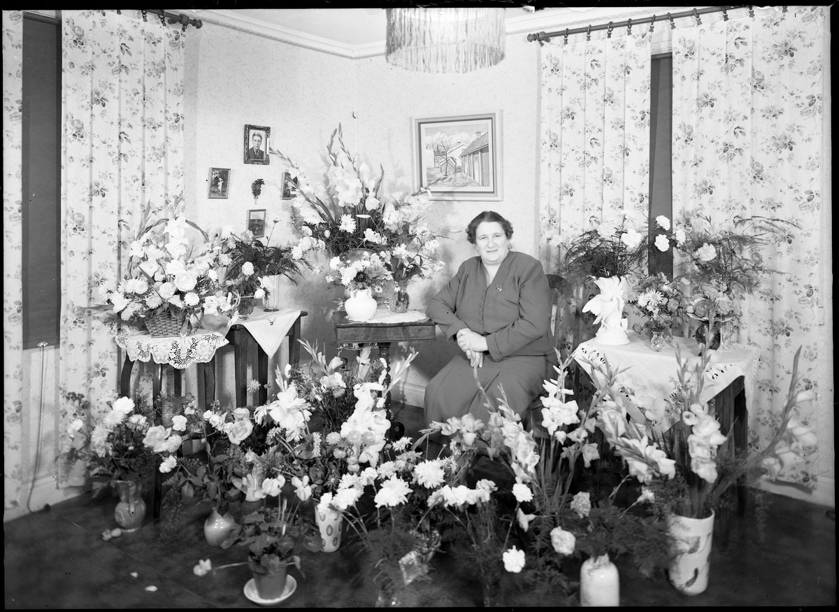 Fru Engdahl porträtterad med blommor på sin födelsedag. Kv Jägaren, Drottninggatan - Östra Ringgatan. 1940/50