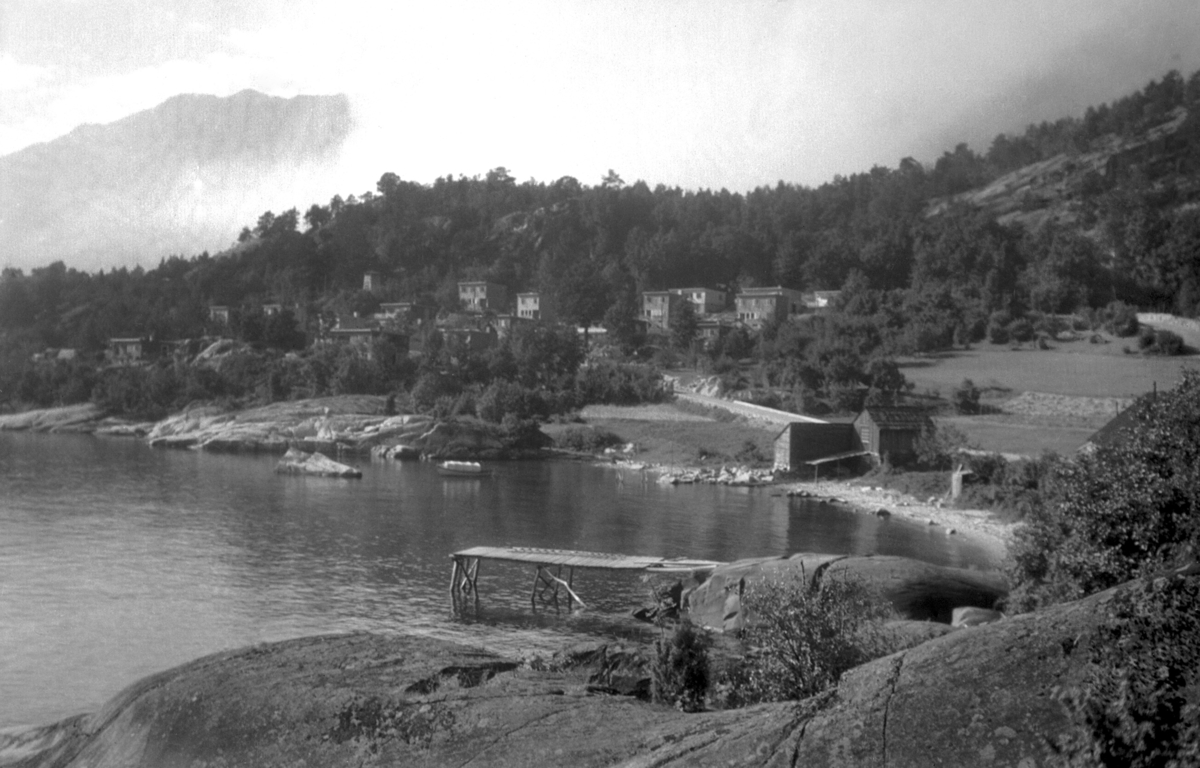 Fotografi av Skjeret. Ålvik, Kvam, Hordaland. Fotograf: Torstein Lofthus. Det har kommet opplysninger om at foto trolig tatt i 1938/1939, rett etter at funkishusene i bakgrunnen var innflytningsklare. Husene er tegnet av arkitekt Nicolai Beer og befinner seg på Kvam Herad sin gulliste.