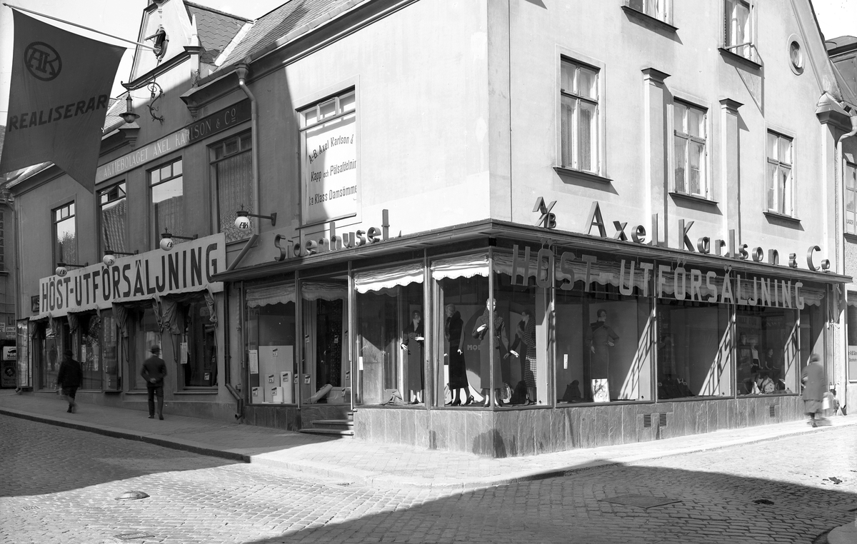 Realisation vid Axel Karlsons i Linköping, länge stadens ledande ekipering. Rörelsen grundades redan 1877 och från 1887 var den förlagd i den så kallade Holmbergska gården. När Axel Karlson gick bort 1915 övertogs verksamheten av hans söner, vilka 1922 gav butiken i stort det utseende som ses på fotografiet.