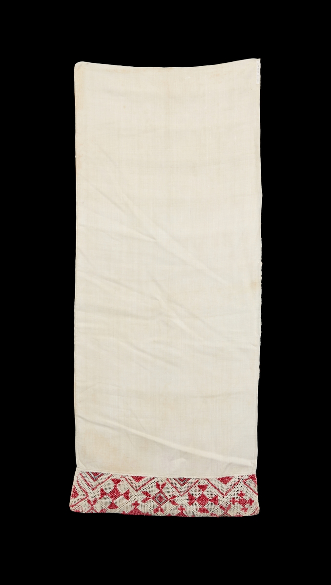 Långörngott. Linnelärft med broderi och märkning i korsstygn i rött "KAK 1849". Huvan sydd i näversöm med urdragna trådar i båda riktningarna, sydd i rött och blått bomullsgarn och vitt lingarn.