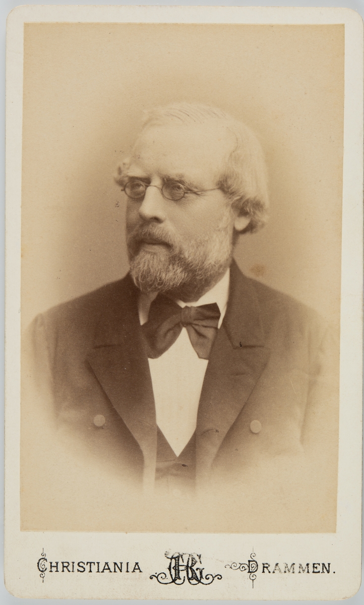 Portrett av mann med skjegg og briller.