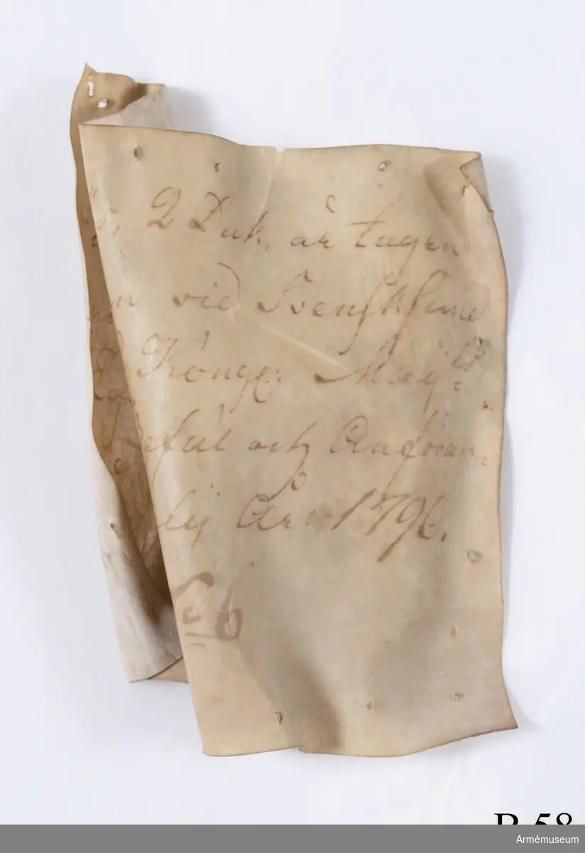 Etikett med text: "Denna Göös, 2 Duk, är tagen uti Bataillen vid Svensksund under Hans Kongl. Maij.st Egit Höga Befäl och Anförande den 9. Julij År 1790. No 6".