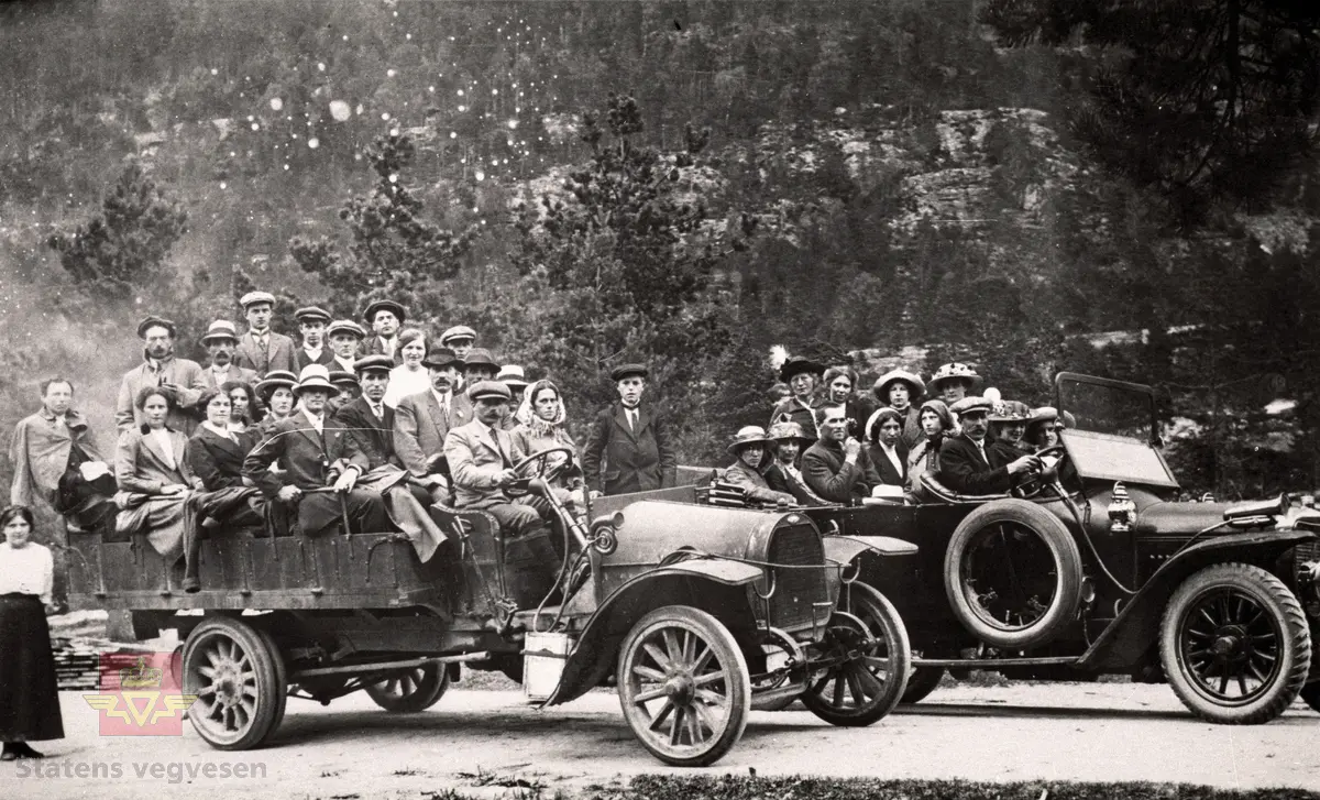 Ein lastebil og ein personbil på tur ved Kleivedammen på Sandane rundt 1920.

Bilen til venstre er ein Opel med Olai Farsund som sjåfør, medan sjåfør Samuel S. Veiteberg køyrer den andre bilen, ein Adler. 