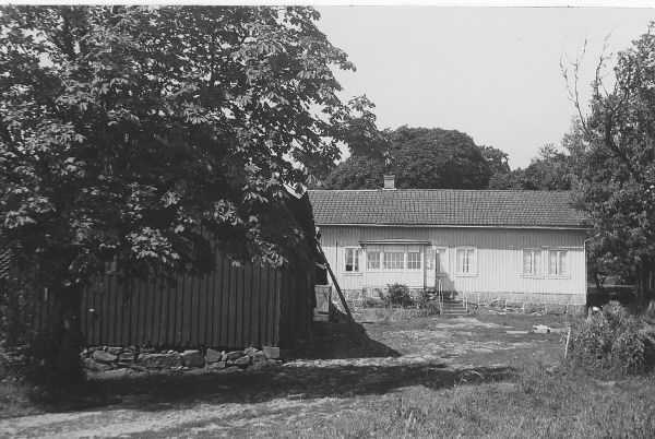 Vrå gård i Vallda med bostadshuset i bakgrunden och en ekonomibyggnad i förgrunden.