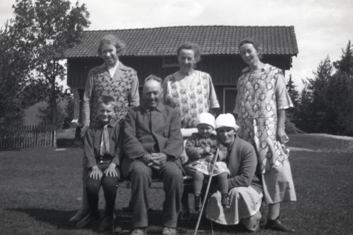 Ei gruppe menneske samla ute.  T. h Astrid Terjesen med dotter Tordis i armane.  På det andre sit Tordis t.h for mannen.  Bildet er tatt på Heisholt 25.6.1928.