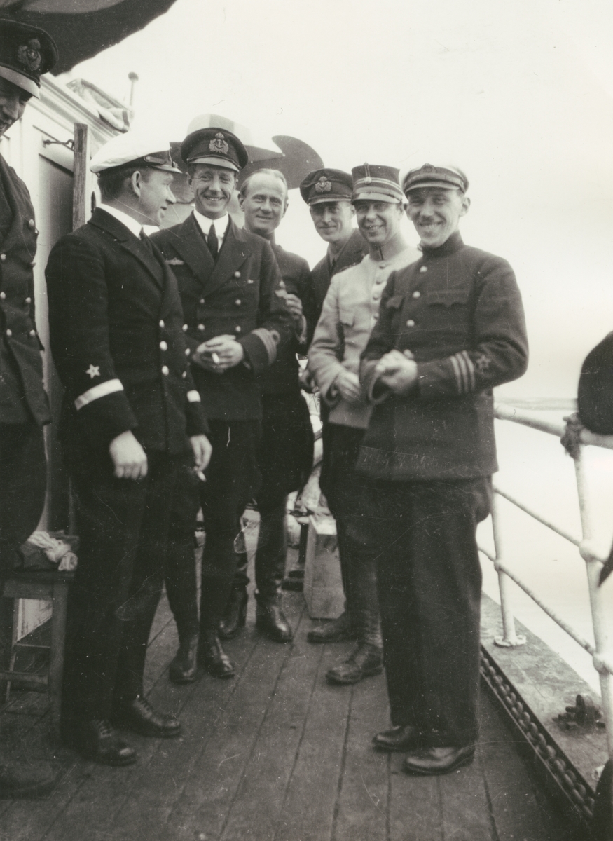 Fotografi från svenska undsättningsexpeditionen 1928. Motiv av en grupp uniformsklädda män ombord på "Quest". Från vänster: Löjtnant Rosensvärd, Amiral Gras, Kapten Tornberg, Löjtnant Lundborg, Löjtnant Jacobsson, Löjtnant Schyberg, Kapten Chickmovsky.