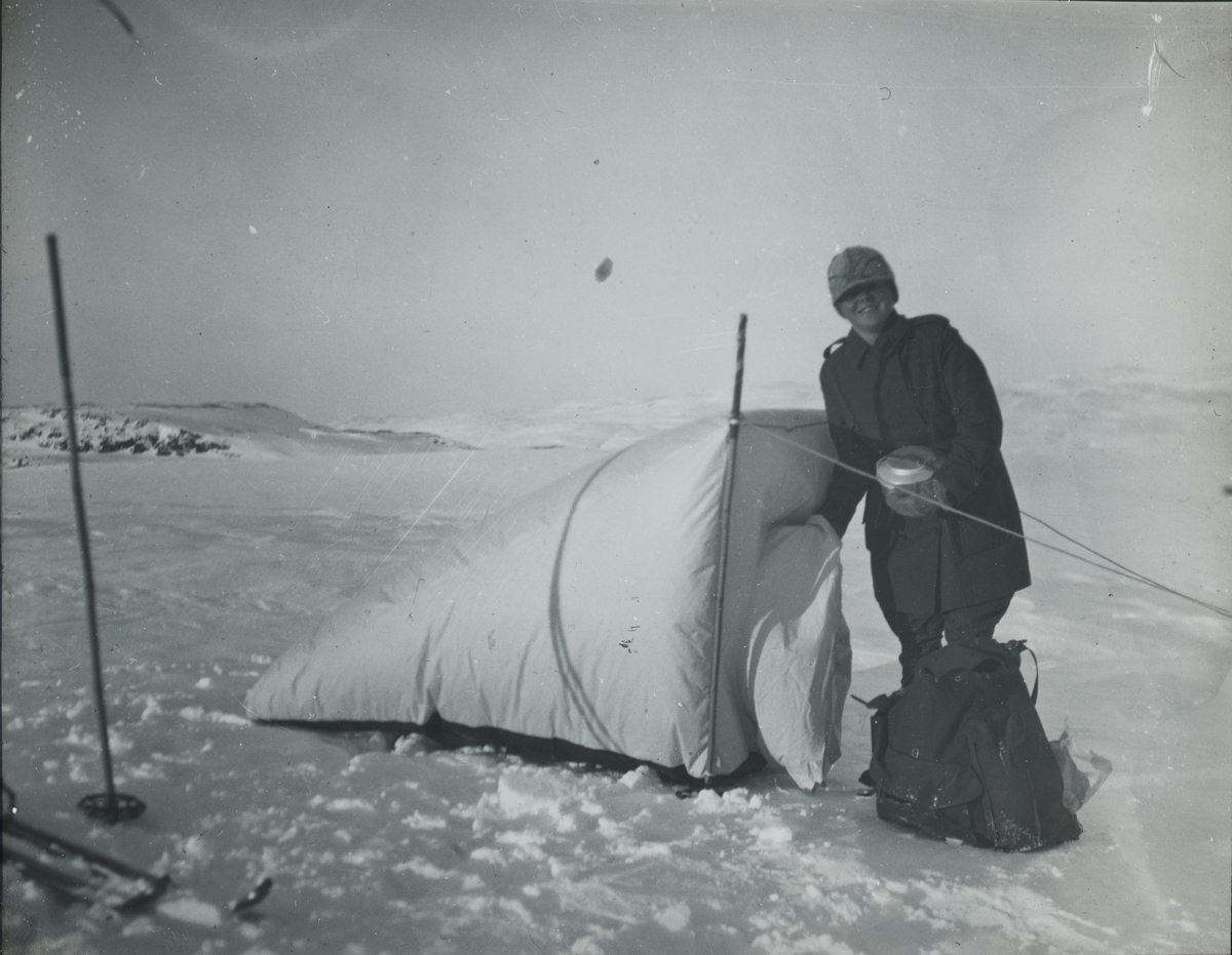 Fotografi från expedition till Spetsbergen. Motiv av kvinna med tält i snölandskap.
