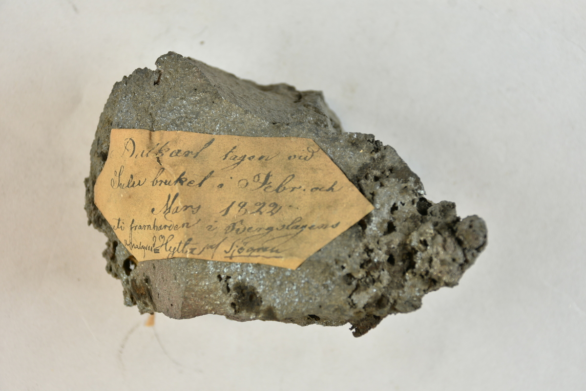 Materialprov med påklistrad lapp "Dalkarl tagen vid Sulu bruket i Febr. och Mars 1822 uti framharven i Bergslagens Hytta, analyserad af Sjögren",